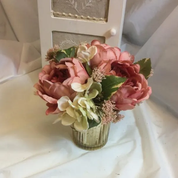 A flower arrangement of large peonies & hydrangea